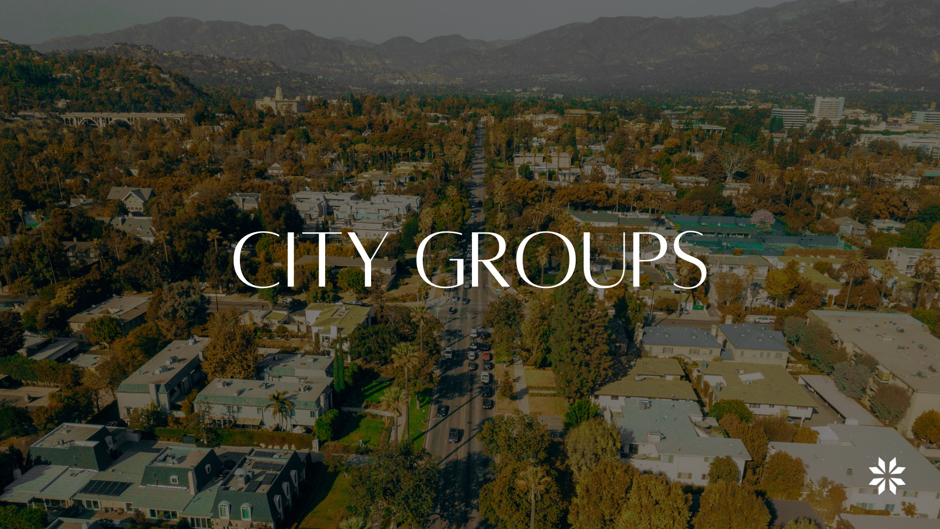 An aerial view of Pasadena neighborhoods with the San Gabriel mountains beyond